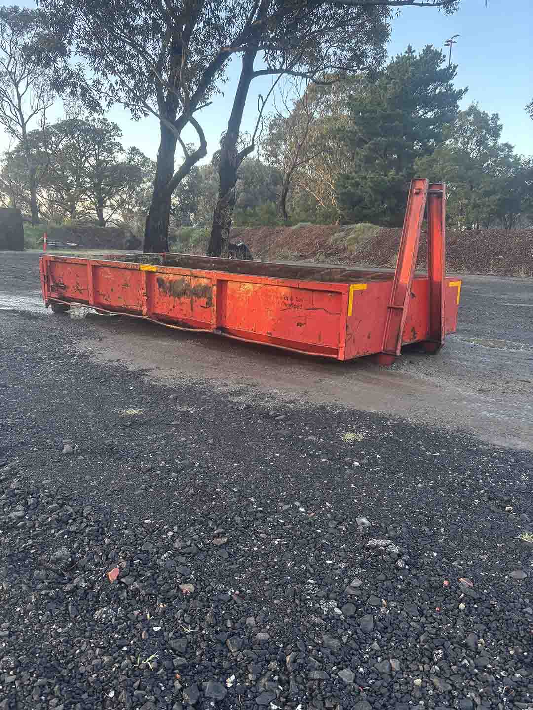s2a Red 8m³ walk-in bin on a gravel yard under gum trees