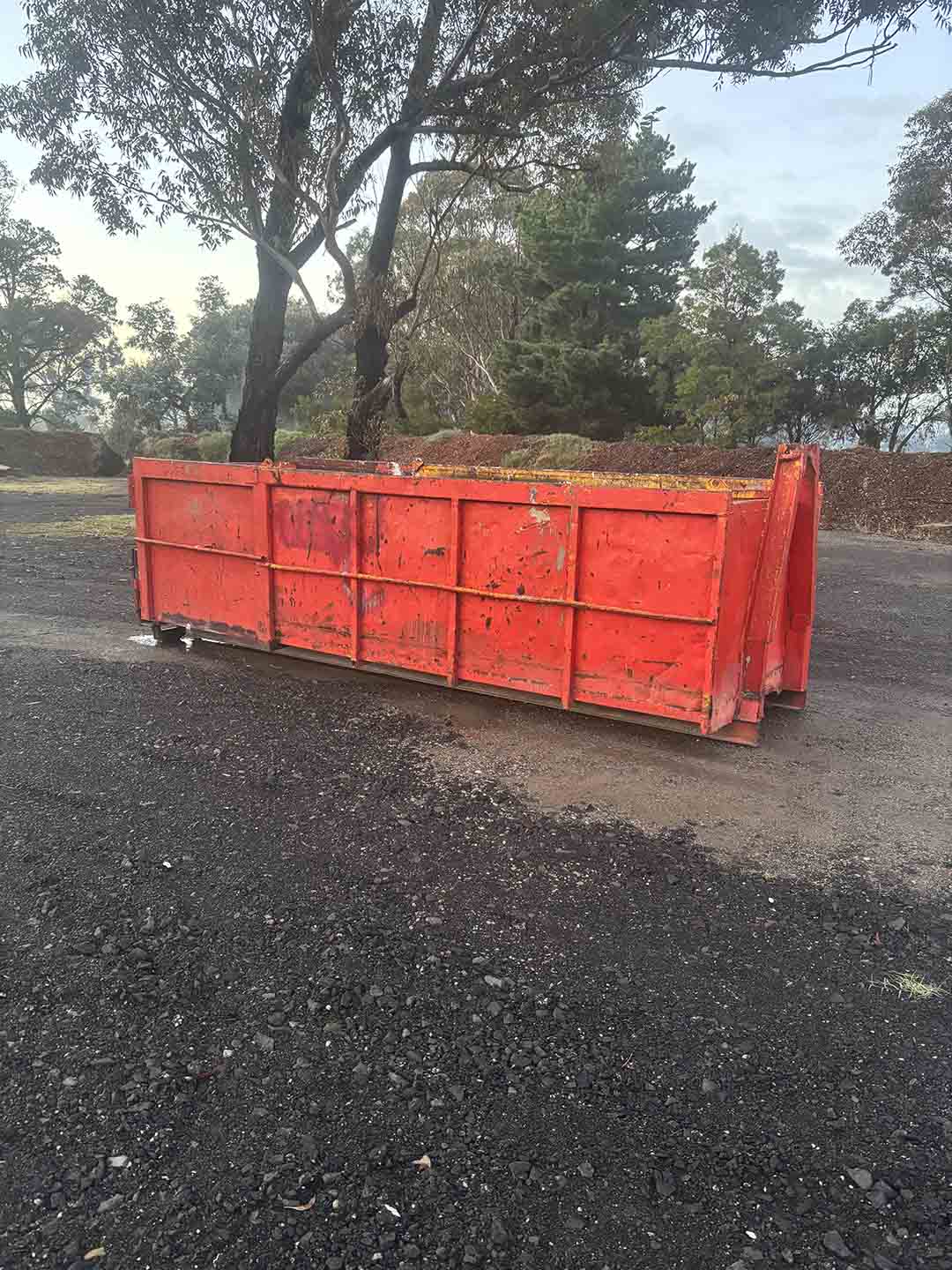 s4a Red 12m³ walk-in bin on a gravel yard under gum trees