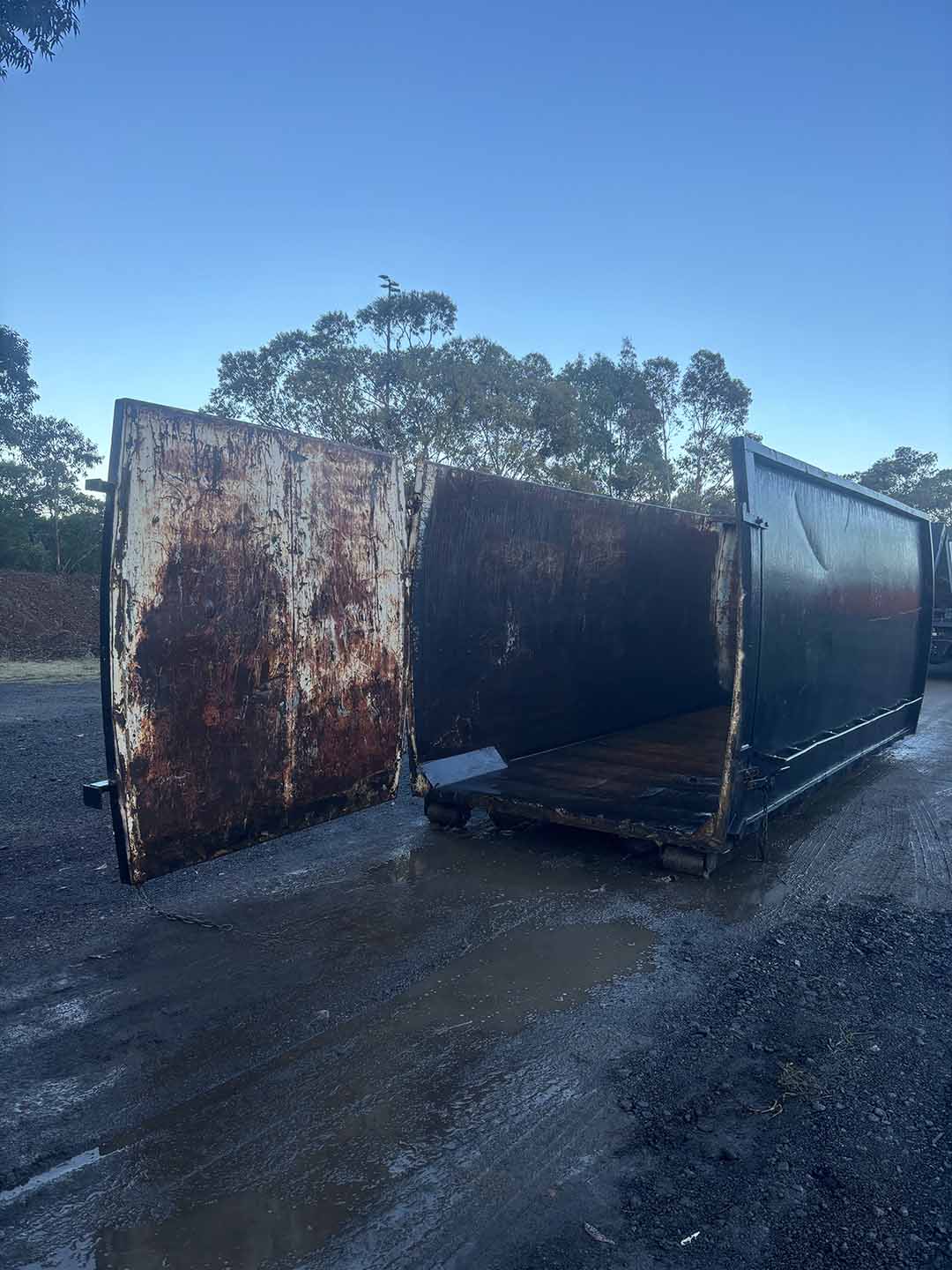 s7c Black 30m³ walk-in bin with its rusty rear doors open